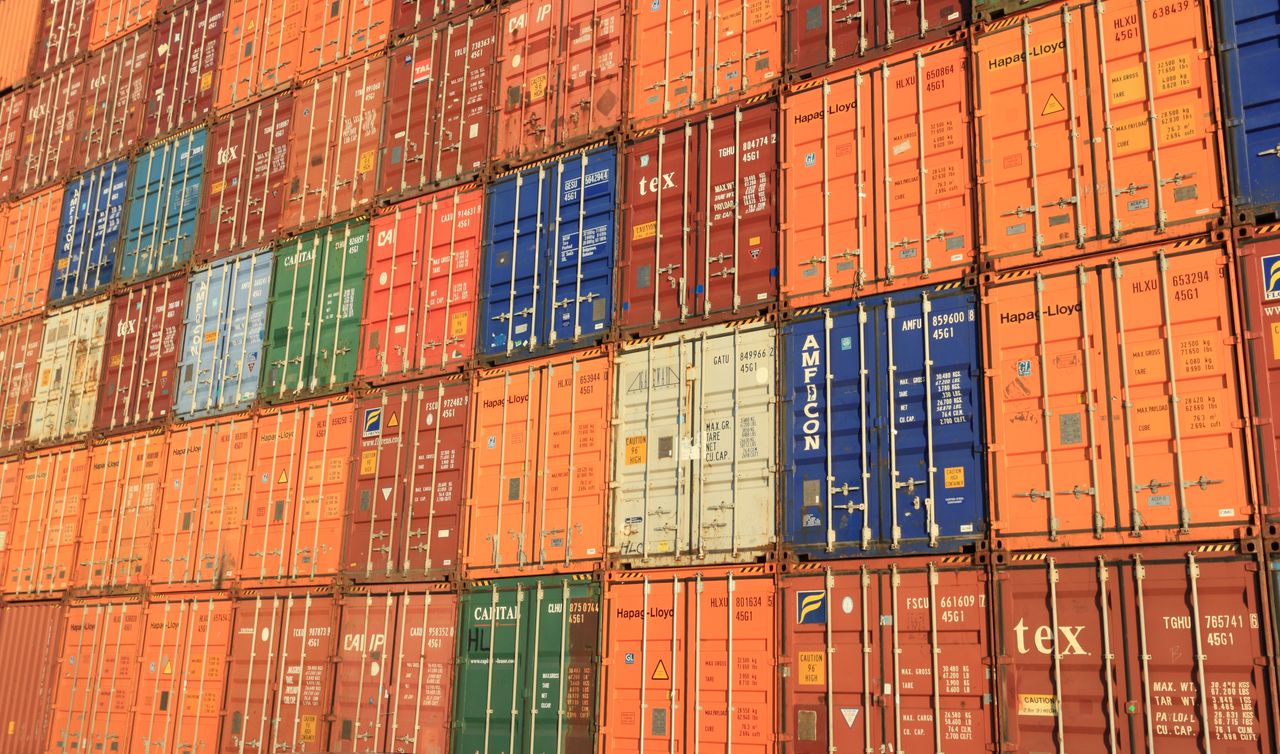 Services Colorful shipping containers stacked in a harbor, symbolizing global trade.